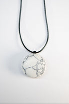 Necklace with a white marbled pendant on a light gray background